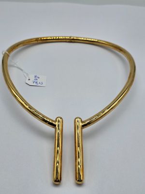 un collier plaqué or avec deux barrettes sur fond blanc