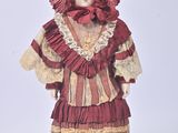 a doll that is wearing a red dress and hat