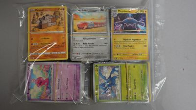 de nombreuses cartes Pokémon dans un sachet en plastique posé sur une table