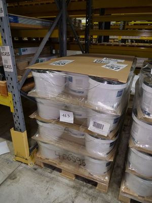 many rolls of toilet paper sitting on a pallet in a warehouse
