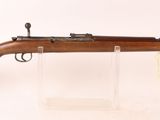 un vieux fusil posé sur un socle transparent, devant un fond blanc