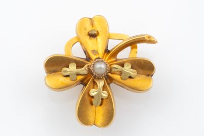 an image of a gold flower brooch with a pearl in the center
