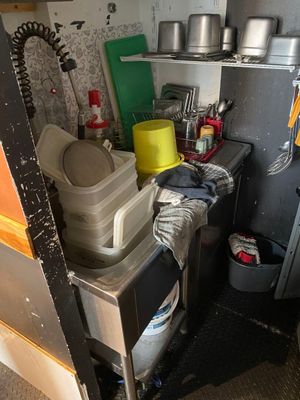 a small kitchen with pots and pans on the shelves