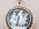 a close up of a pendant with a woman and a child