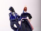a figurine of a man riding a motorcycle with a woman on the back