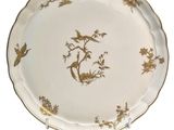 a white plate with gold trim and birds on it