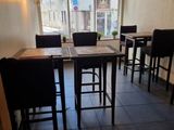 tables and chairs in a room with a large window and a tiled floor
