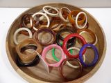 a wooden bowl filled with lots of different colored rings
