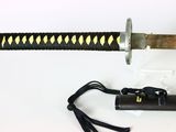a black and gold samurai sword on a white surface