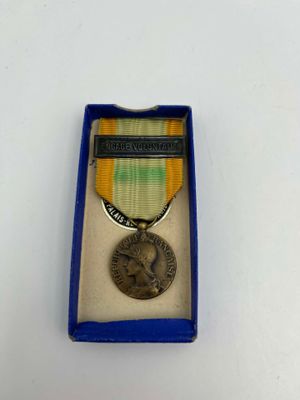 an image of a medal in a blue box on a white surface