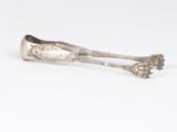 a silver spoon with a flower design on the handle