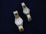 pair of two ladies ' s watches on a black surface