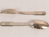 two silver spoons and a fork on a table