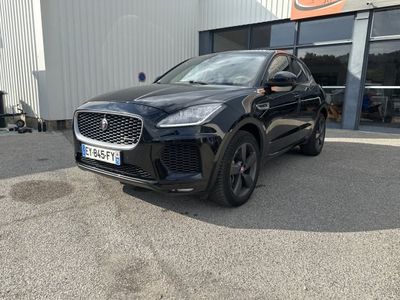 un SUV Jaguar noir garé devant un immeuble