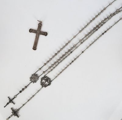 un chapelet et une croix posés sur une table blanche, sur fond blanc