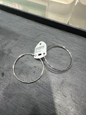 une paire de boucles d'oreilles en anneau argentées posées sur une table
