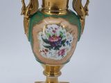 a gold vase with a floral design on it