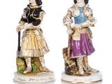 two figurines of women with a dog and a basket of flowers