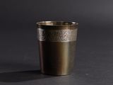 an image of a metal cup on a black surface
