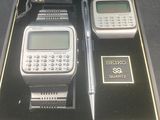 a box with a watch, pen, and calculator in it