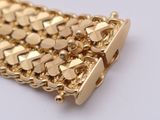 an image of a close up of a gold bracelet on a white surface