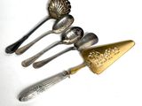 five spoons and a spatula on a white surface