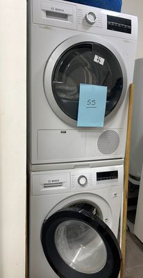 two washers and a dryer stacked on top of each other in a room