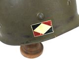 an old army helmet on a wooden base with a flag on it