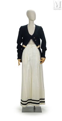 une photo d'un mannequin portant une robe blanche et un cardigan noir
