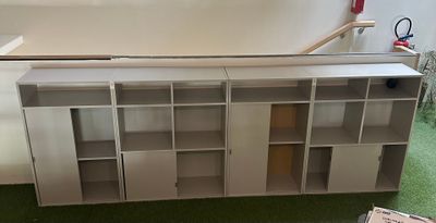 a white bookcase that is sitting on a green carpet