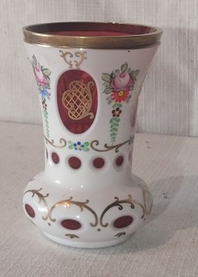 un vase blanc orné d'un motif rouge et or