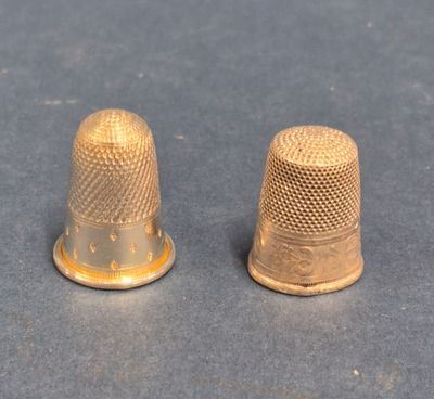 pair of thimbles on a table with a blue background