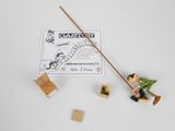 a small toy figurine of a man sitting on a chair with a stick
