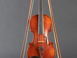 an old violin on a stand against a gray background