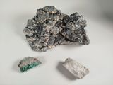 a piece of silver and a rock on a white surface