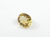 a yellow sapphire stone on a white surface