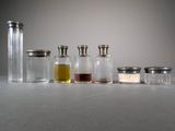 five small glass jars with different colored liquids in them