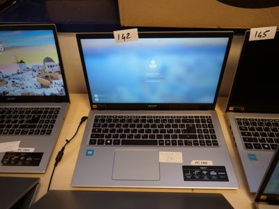 three laptops are sitting on a table with price tags on them