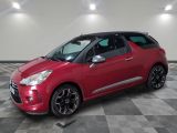 a red citrole parked on a checkered floor in a garage