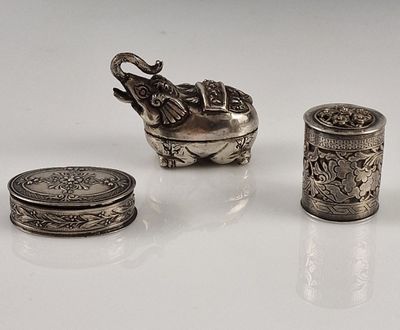 trois objets en argent posés les uns à côté des autres sur une table
