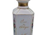 a white bottle with a gold top and flowers on it