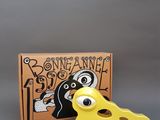 un jouet jaune posé à côté d'une boîte sur laquelle se trouve un morceau de fromage