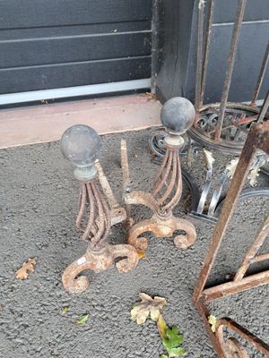 some old rusty objects on the ground outside of a building