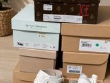 Plusieurs cartons de chaussures sont empilés les uns sur les autres par terre.