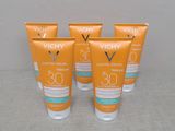 quatre flacons de crème solaire Vichy Capital Sun posés sur une table