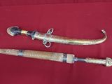 une paire de deux vieilles épées en bois posées sur un tissu rouge