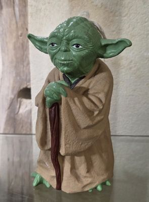 une figurine représentant Yoda tenant une canne