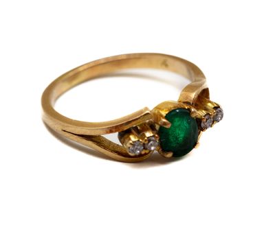 une image d'un gros plan d'une bague en or avec une pierre verte