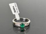an image of a ring with a green stone