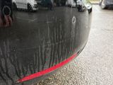 a close up of a car ' s bumper with a red stripe